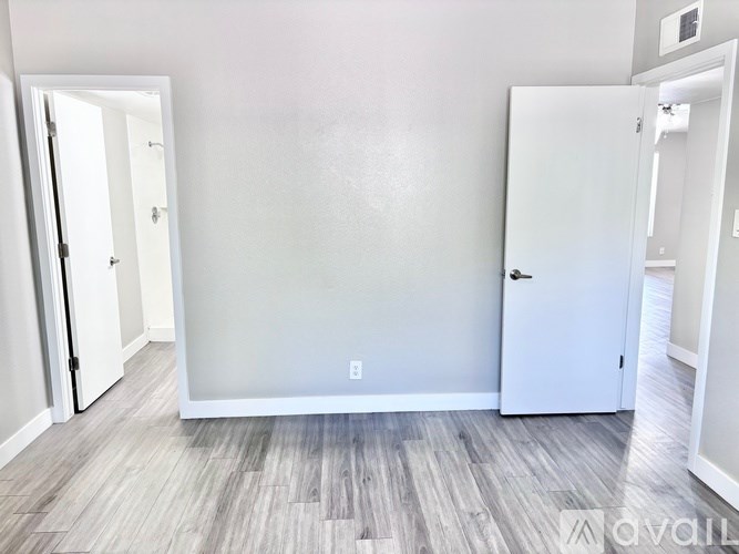 A room with a white door and a grey wall.