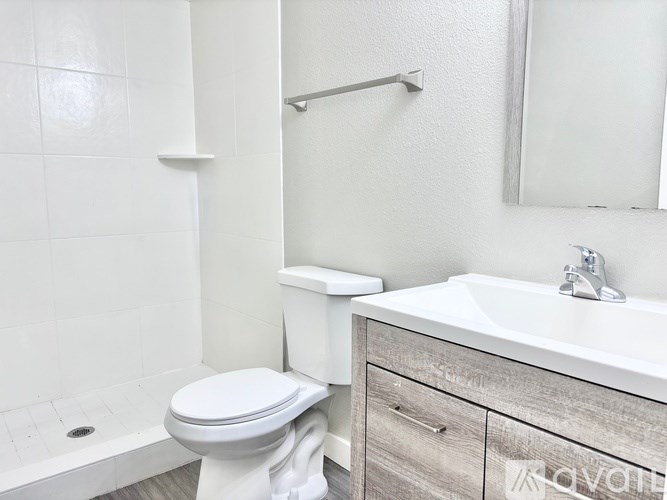 A white toilet sits next to a white sink in a bathroom.