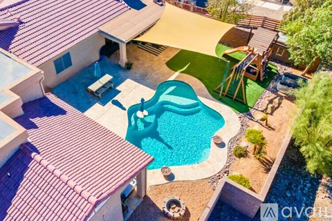 A backyard with a pool and a slide.