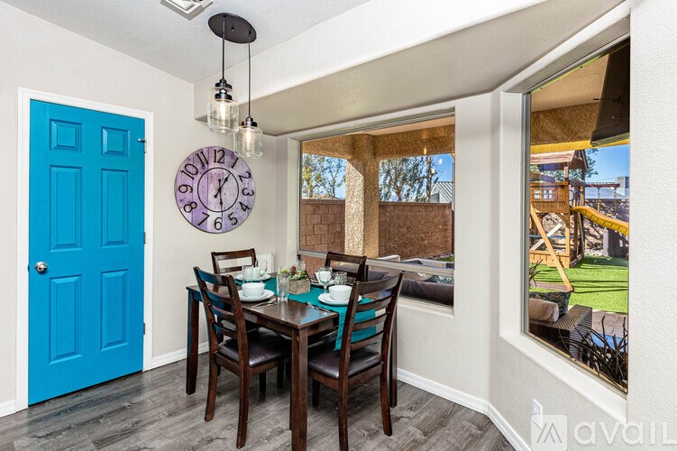 A dining room with a blue door and a large clock on the wall.