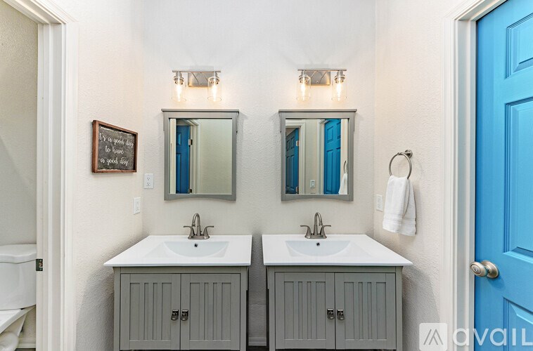 A bathroom with two sinks and a blue door.