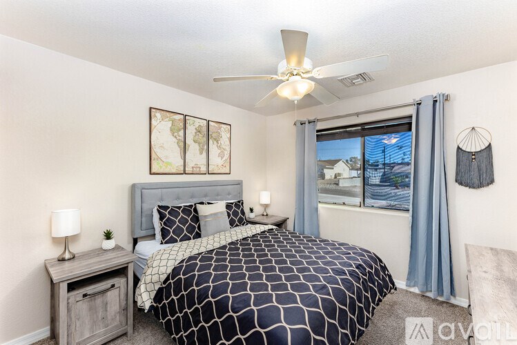A bedroom with a bed, nightstand, and window.