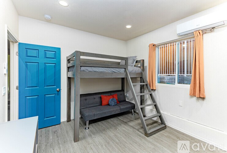 A room with a bunk bed and a blue door.