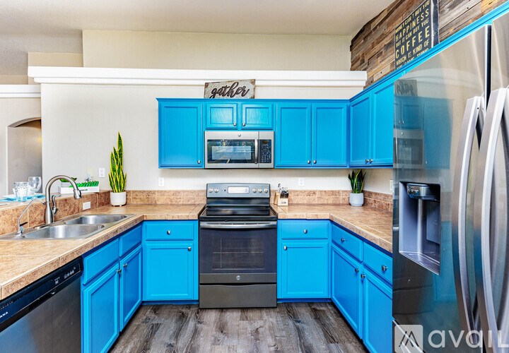 A kitchen with blue cabinets and a wooden sign on the wall.