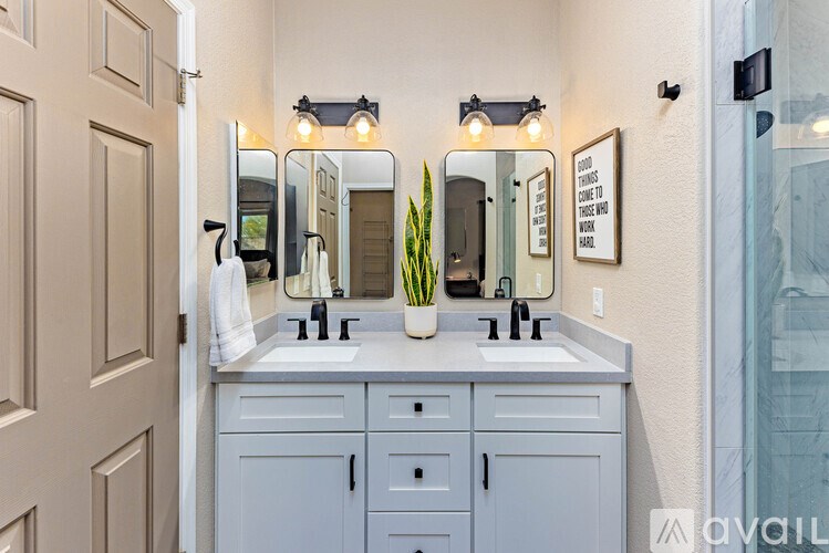 A bathroom with a vanity and a mirror above it.