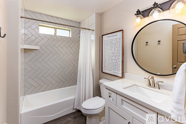 A bathroom with a white toilet, sink, and a bathtub with a shower curtain.