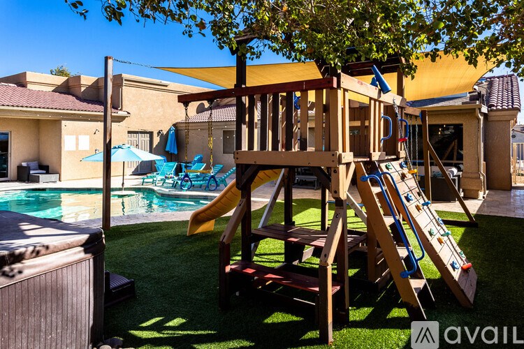 A wooden playset with a slide and a wooden deck.