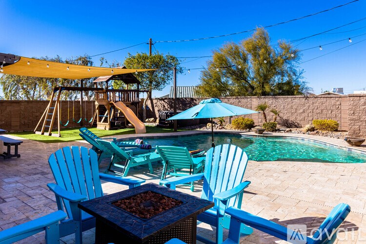 A patio with blue chairs and a table with a bowl of nuts on it.