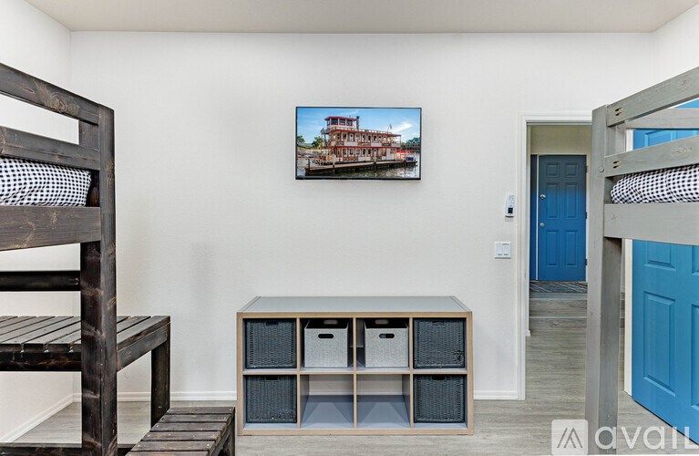 A room with a bed, a bench, and a cabinet with a painting on the wall.