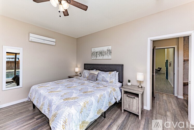 A bedroom with a bed, nightstand, and a ceiling fan.
