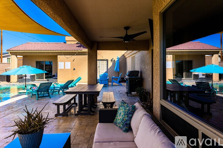A patio with a table, chairs and a ceiling fan.