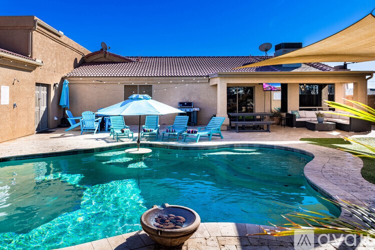 A pool with a table and chairs around it.