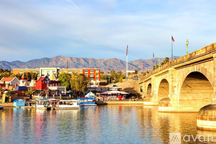 A bridge over a body of water with boats and buildings in the background.