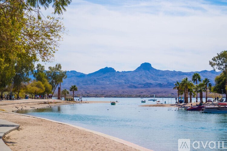 A beach with boats and mountains in the background.