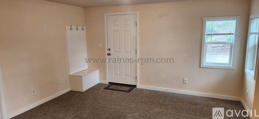 A room with a door, a window, and a bench.