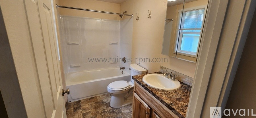 A bathroom with a toilet, sink, and bathtub.