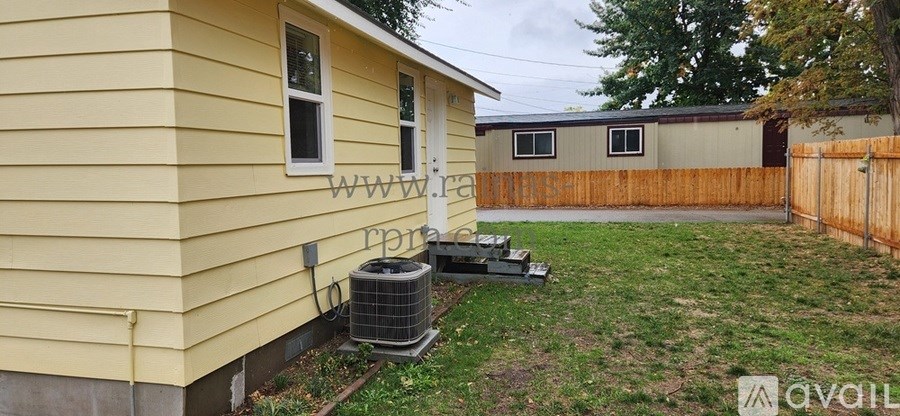 A yellow house with a fence and a window.