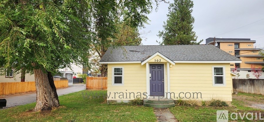 A small yellow house with a blue door is for sale.
