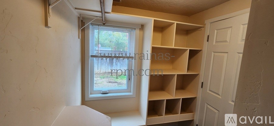 A room with a window and shelving units.