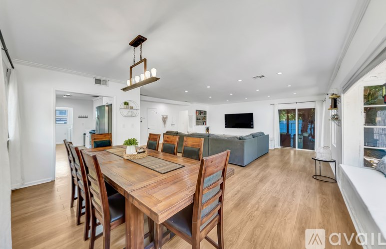 A modern dining room with a wooden table and chairs.