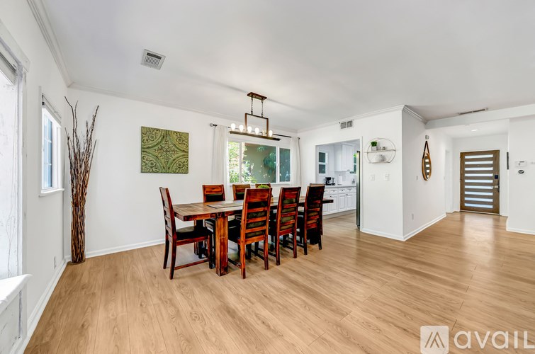 A dining room with a wooden table and chairs.