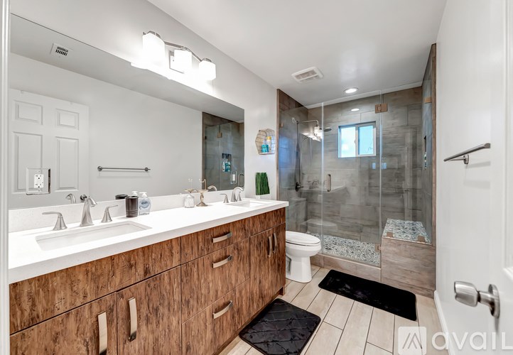 A bathroom with a white sink and a wooden vanity.