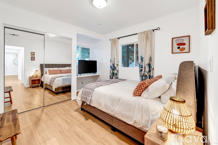 A bedroom with a large bed and a mirror on the wall.