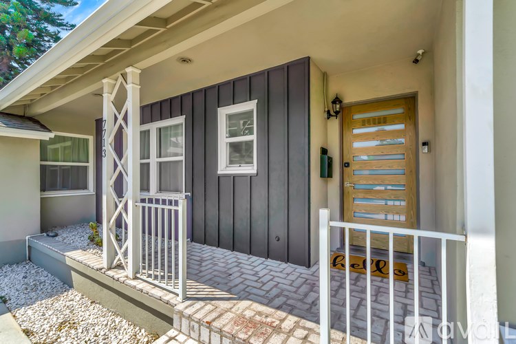 A house with a wooden door and a white railing.