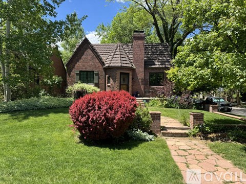 A house with a red bush in front of it.