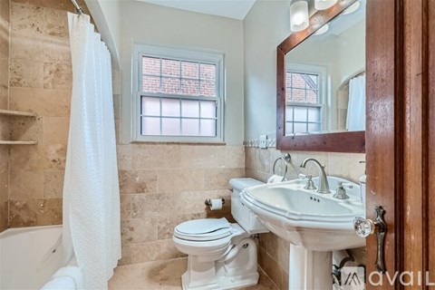 A bathroom with a white toilet, sink, and a window.
