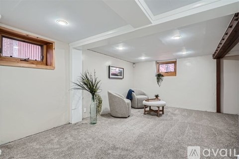 A living room with a grey carpet and a wooden ceiling.