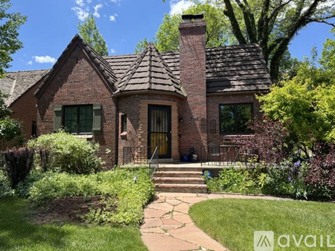 A brick house with a green lawn in front.