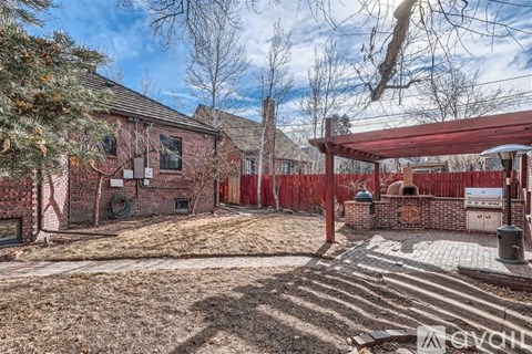 A red brick house with a covered patio area.