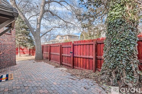 A red fence with a tree growing on it.