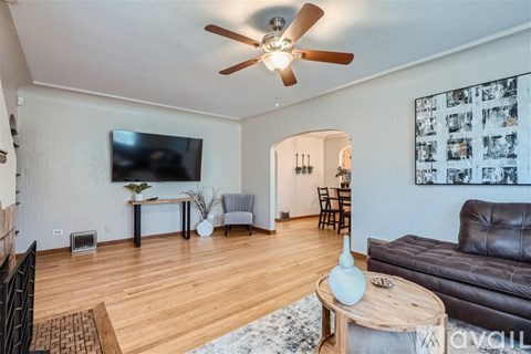A living room with a leather couch, a coffee table, and a television.