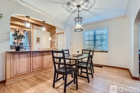 A dining room with a wooden table and chairs.