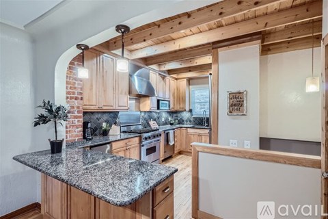 A kitchen with wooden cabinets and granite countertops.