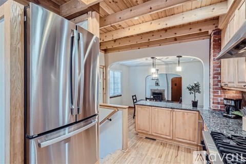 A modern kitchen with a stainless steel refrigerator and wooden cabinets.