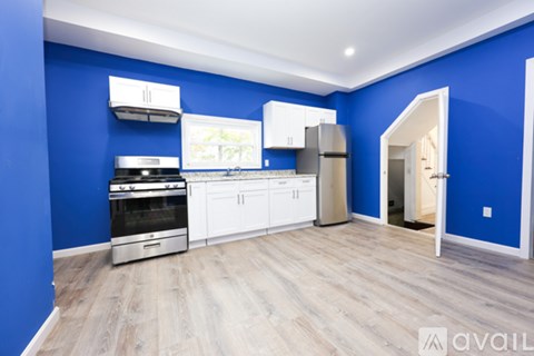 A kitchen with blue walls and white appliances.