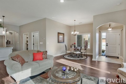 A living room with a grey couch and a glass coffee table.