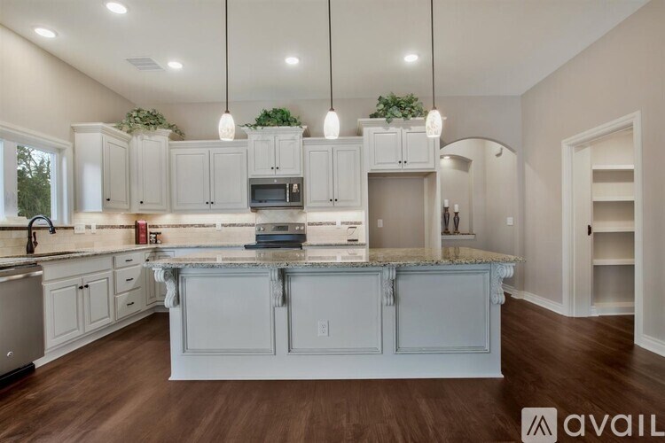 A modern kitchen with a center island and pendant lights.