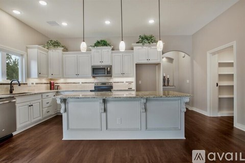 A modern kitchen with a center island and pendant lights.