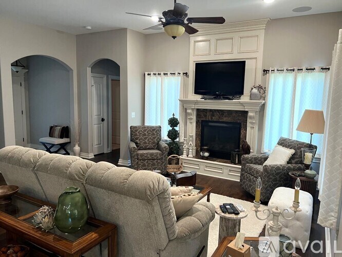 A living room with a fireplace, a couch, a chair, and a television.