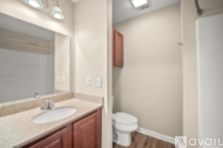 A bathroom with a sink, toilet and mirror.