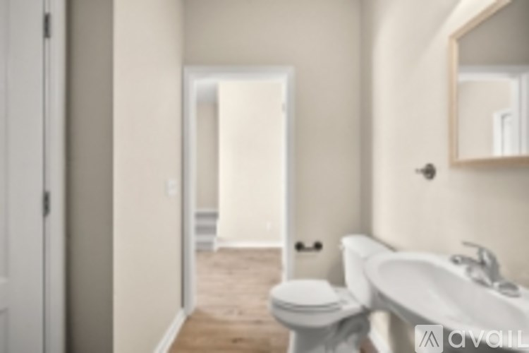 A bathroom with a toilet, sink and mirror.