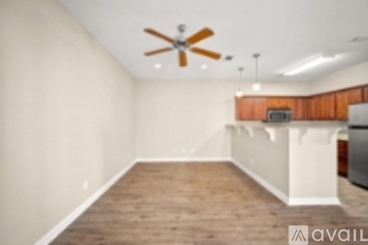A room with a ceiling fan and wooden flooring.