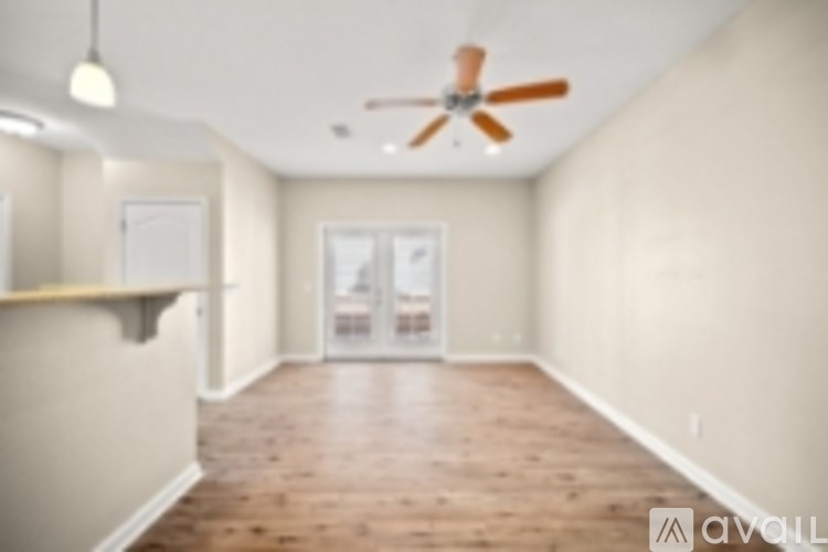 A room with a ceiling fan and wooden flooring.