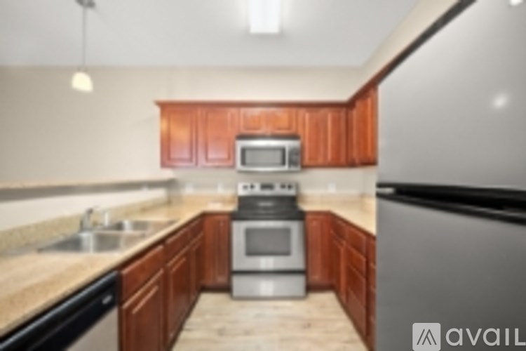 A kitchen with wooden cabinets and a stainless steel refrigerator.