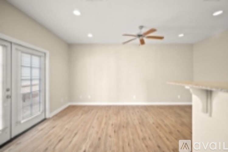 A room with a ceiling fan and wooden flooring.