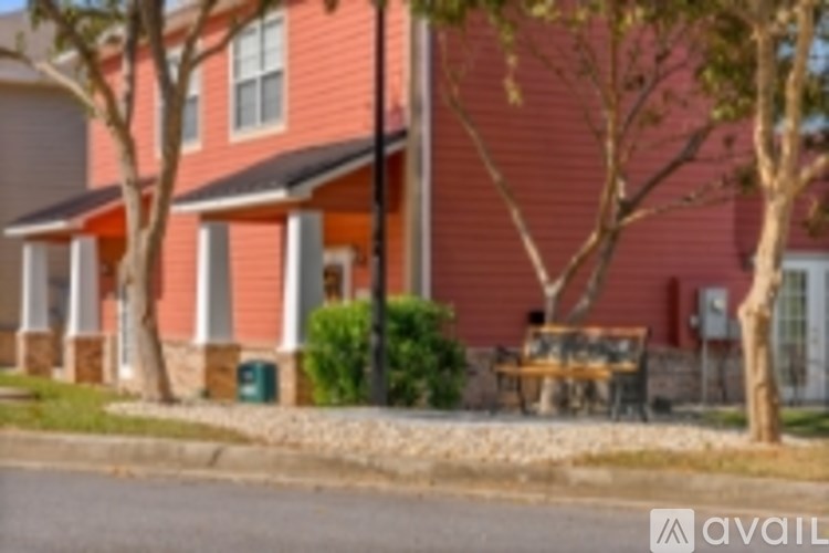 A red house with a tree in front.
